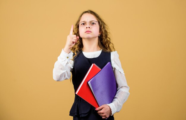 Schulprüfungskonzept Vorbereitung auf die Prüfung Vorbereitung auf Prüfungen in der Bibliothek Formelle Kleidung für kleine Kinder Formelle Bildung und Homeschooling Wissen prüfen Abschlussprüfung kommt Mädchen halten Lehrbuch-Ordner-Test