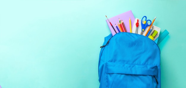 Schultasche Rucksack mit Schulgeräten auf grünem Hintergrund Kopierraum für Text