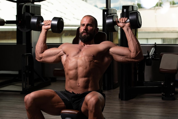 Schultern trainieren mit Kurzhanteln in einem Fitnessstudio