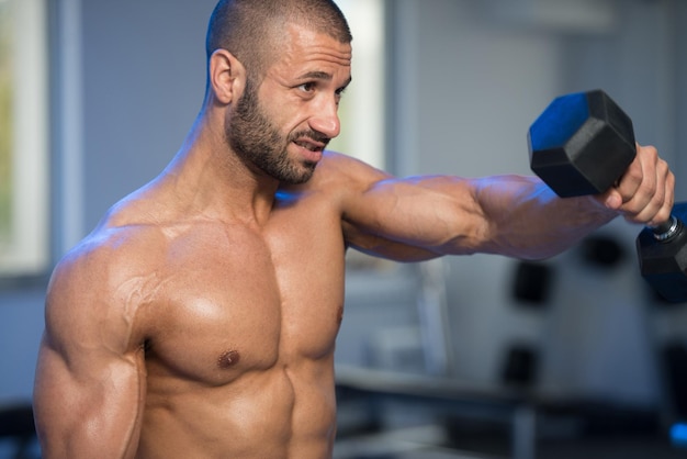 Schultern trainieren mit Kurzhanteln in einem Fitnessstudio