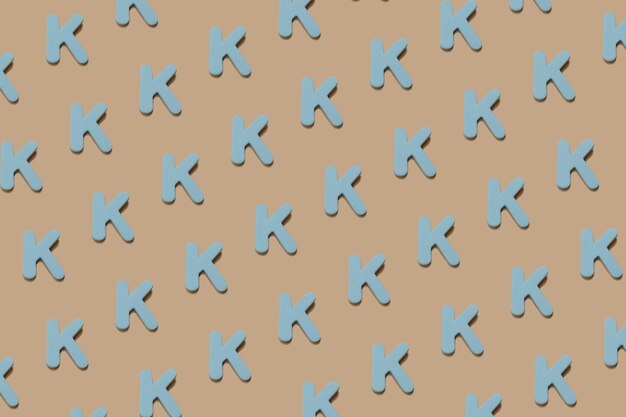 Schulthema-Kulisse aus bunten blauen Schaumstoffbuchstaben auf chaotischer Weise auf einem beigefarbenen Papierhintergrund. Kreativ zurück in die Schule flach, Draufsicht mit Kopienraum.