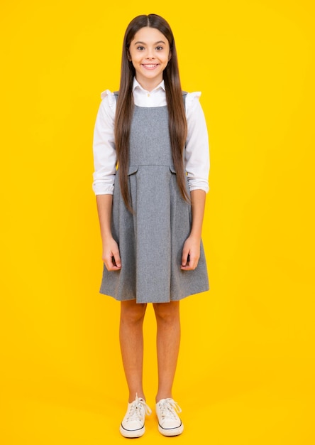 Schuluniform Teenager Kind Mädchen Freizeitkleidung posiert isoliert auf gelbem Hintergrund im Studio Lifestyle-Konzept für Kinder