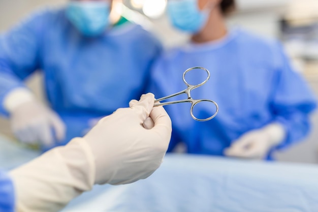 Schuss aus niedrigem Winkel im Operationssaal Assistent überreicht Instrumenten an Chirurgen während der Operation Chirurgen führen Operationen durch Professionelle Ärzte führen Operationen aus