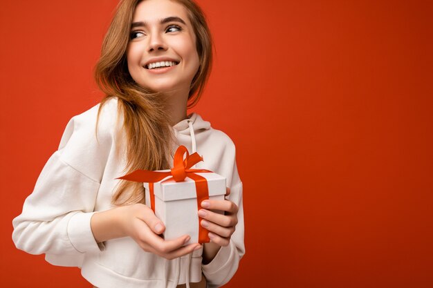 Schuss der attraktiven positiv lächelnden jungen blonden Frau