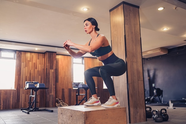 Schuss der jungen Frau, die mit einer Box im Fitnessstudio trainiert