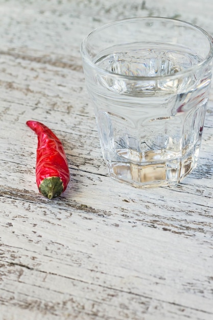 Schuss Wodka mit Cayennepfeffer auf einem alten weißen Holztisch