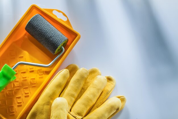 Schutzhandschuhe aus Leder Farbtablettwalze auf weißer Oberfläche