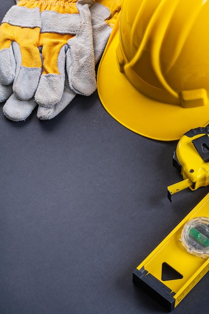 Schutzhandschuhe Helm Tapeline Level im Copyspace auf schwarzem Hintergrund organisiert