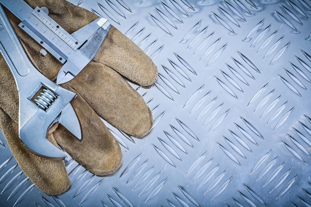 Schutzhandschuhe Messschieber verstellbarer Schraubenschlüssel auf kanalisiertem Blechkonstruktionskonzept