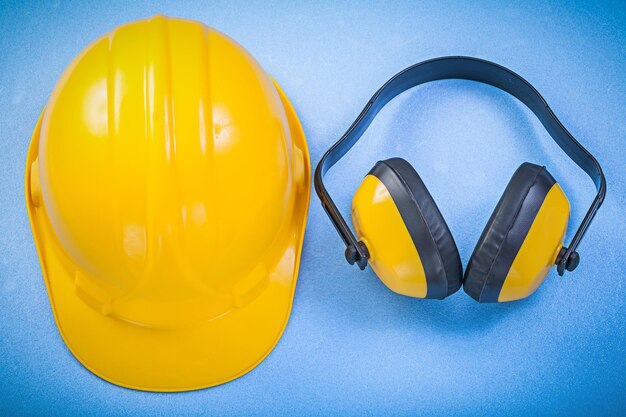 Schutzhelm mit Ohrenschützern auf blauem Hintergrund Baukonzept