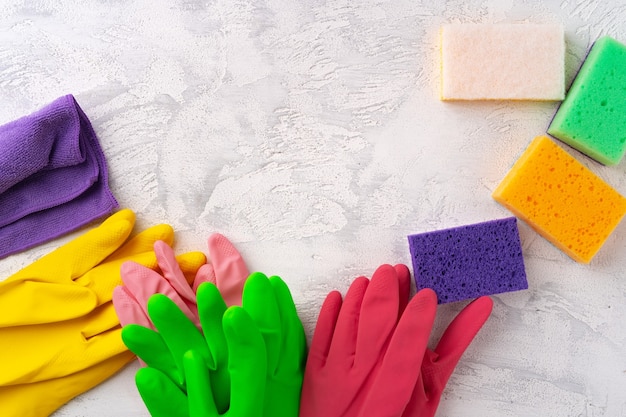 Schwämme und Gummihandschuhe zum Reinigen auf grauem Hintergrund