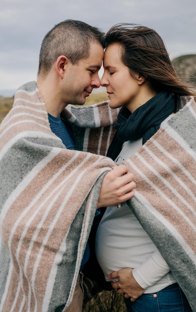 Schwanger mit Ehemann, der mit einer Decke bedeckt ist
