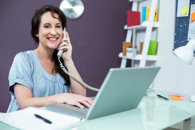 Schwangere Frau am Telefon zu Hause