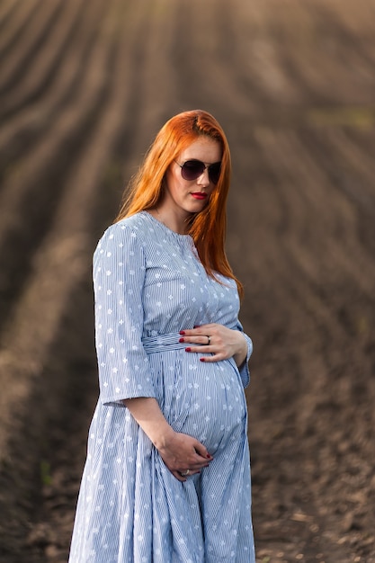 Schwangere Frau auf dem Feld