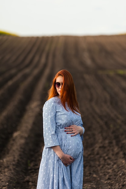 Schwangere Frau auf dem Feld