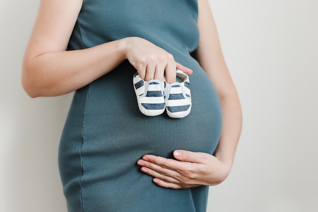 Schwangere Frau Bauch mit Baby Booties