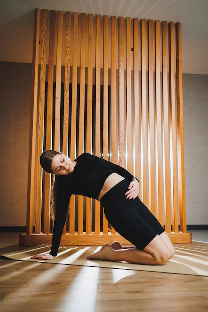 Schwangere Frau beim Sport auf der Matte zu Hause Junge schwangere Frau beim Stretching und Yoga zu Hause Aktivität während der Schwangerschaft