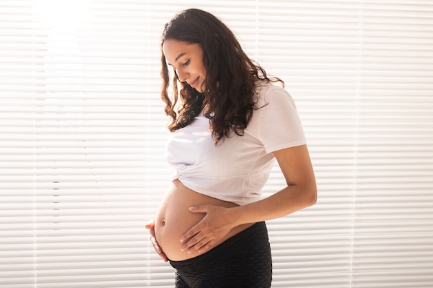 Schwangere Frau berührt ihren Bauch