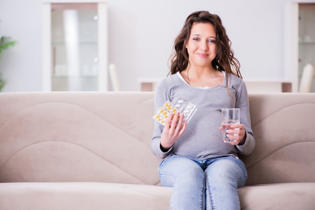 Schwangere Frau, die auf Sofa sitzt