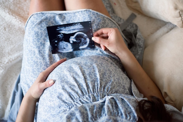 Schwangere Frau, die Baby-Ultraschall-Scan betrachtet
