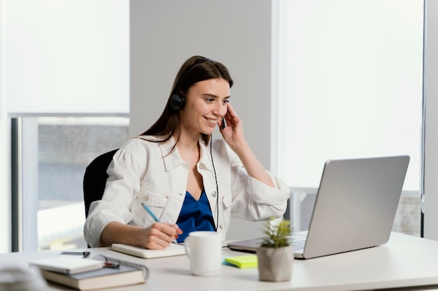 Schwangere Frau, die einen Anruf bei der Arbeit hat