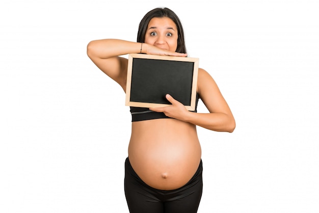 Schwangere Frau, die etwas auf Tafel zeigt.