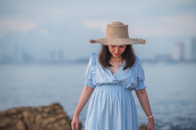 Schwangere Frau, die glücklich zum Meer reist