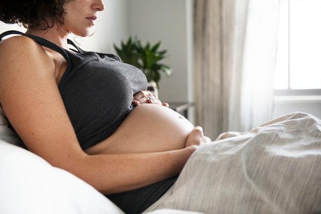 Schwangere Frau, die im Bett liegt