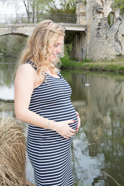 Foto schwangere frau gefühl hände baby posiert im see park im freien