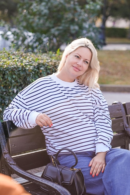 Foto schwangere frau geht an einem sonnigen tag durch die stadt