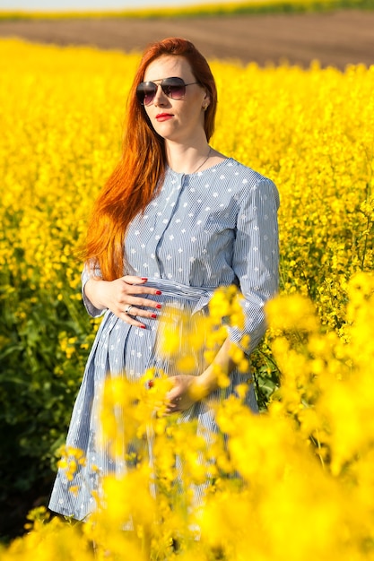 Schwangere Frau im gelben Feld