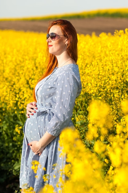 Schwangere Frau im gelben Feld