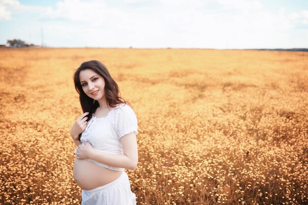 Schwangere Frau in der Natur für einen Spaziergang im Herbst