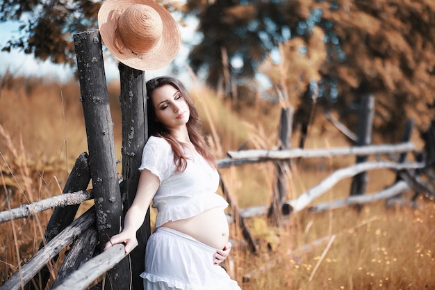 Schwangere Frau in der Natur für einen Spaziergang im Herbst