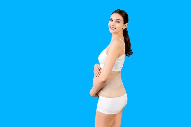 schwangere Frau in Unterwäsche mit Schwangerschaftsgürtel