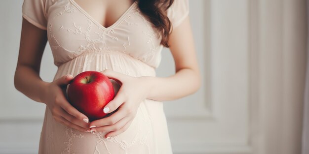 Schwangere Frau mit einem Apfel in der Hand Gesunde Ernährung