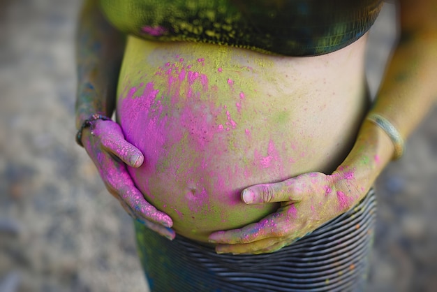 Schwangere Frau mit Holi-Farben