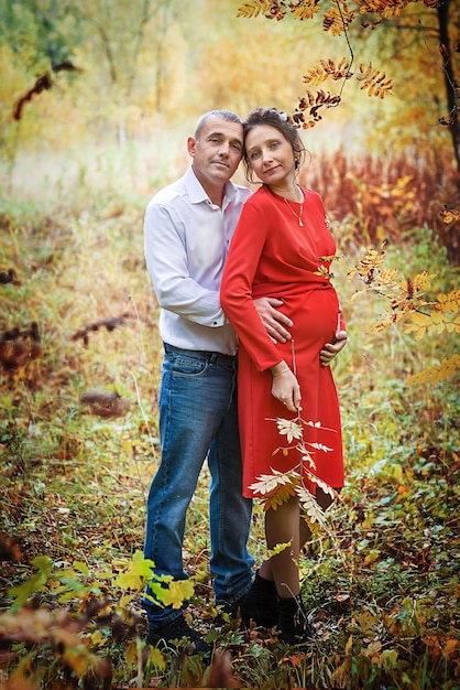 Schwangere Frau mit ihrem Mann im Herbstpark