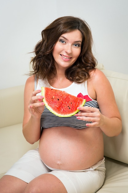 Schwangere Frau mit Wassermelone in den Händen