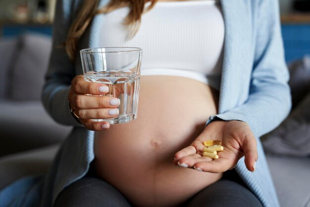 Schwangere Frau nimmt zu Hause Vitamine ein