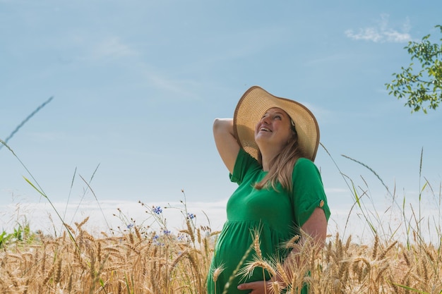 Schwangere Frau steht auf dem Weizenfeld
