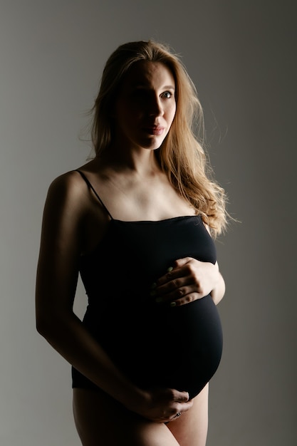 Schwangere Frau streichelt ihren Bauch auf weißem Hintergrund kopieren Raum das Konzept der gesunden Verdauung...