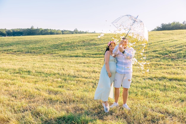 Schwangere Frau und ihr Ehemann auf dem Feld mit transparentem Bauch