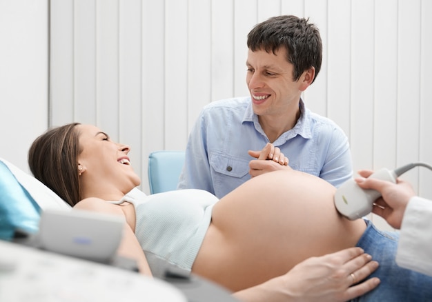 Schwangere Frau und Mann auf Ultraschalluntersuchung im Krankenhaus.
