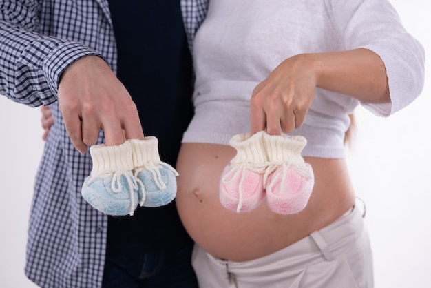 Foto schwangere frau und mann hält schuhe für baby