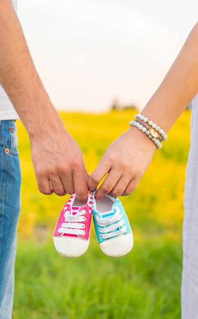 Schwangere Frau und Mann halten Babyschuhe.