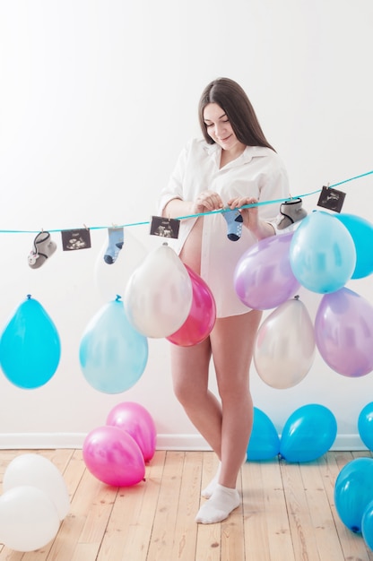 Schwangere Frauen mit Luftballons drinnen