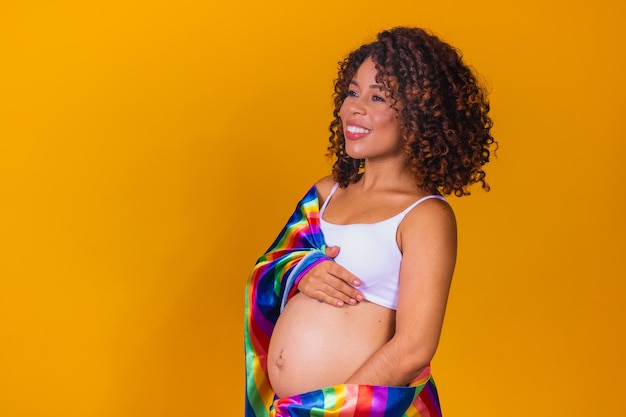 Schwangere lesbische Frau mit Schwulenstolz, Regenbogenfahne, LGBTQ-Hintergründe mit zusätzlichem Kopierraum, LGBTQ-Schwangerschaftskonzept