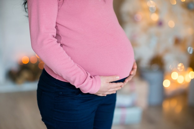 Schwangere Mädchen, Bauch umarmte ihre Arme groß