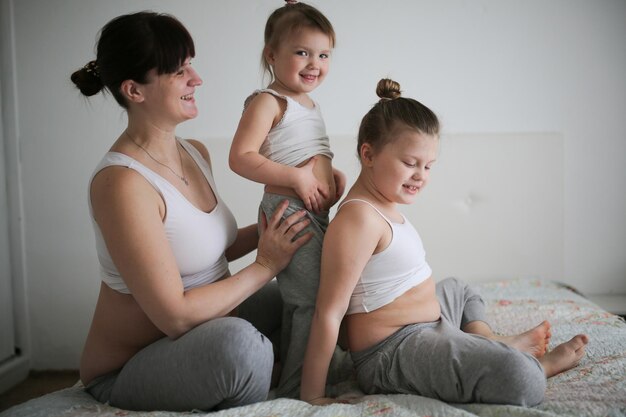 Foto schwangere mutter mit drei töchtern ein lebensstil in einem echten interieur das konzept einer großen familie